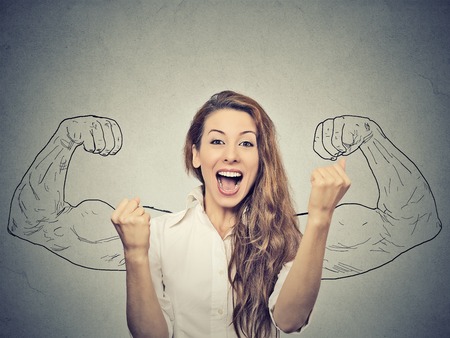38679277 - happy woman exults pumping fists ecstatic celebrates success on gray wall background